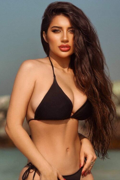 Woman in black bikini at the beach.