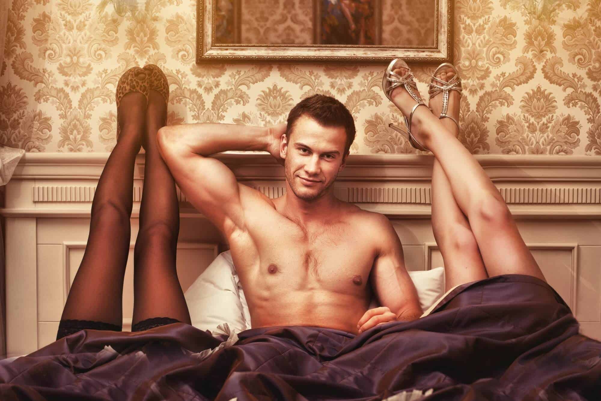 Man in bed with woman's legs up.