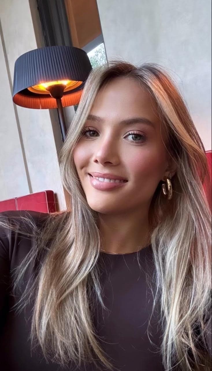 Close-up portrait of a smiling woman with blonde hair.