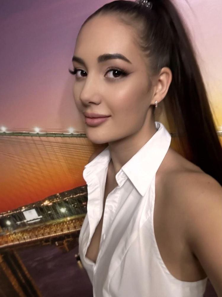 nikilina Woman in white halter-neck shirt with high ponytail.